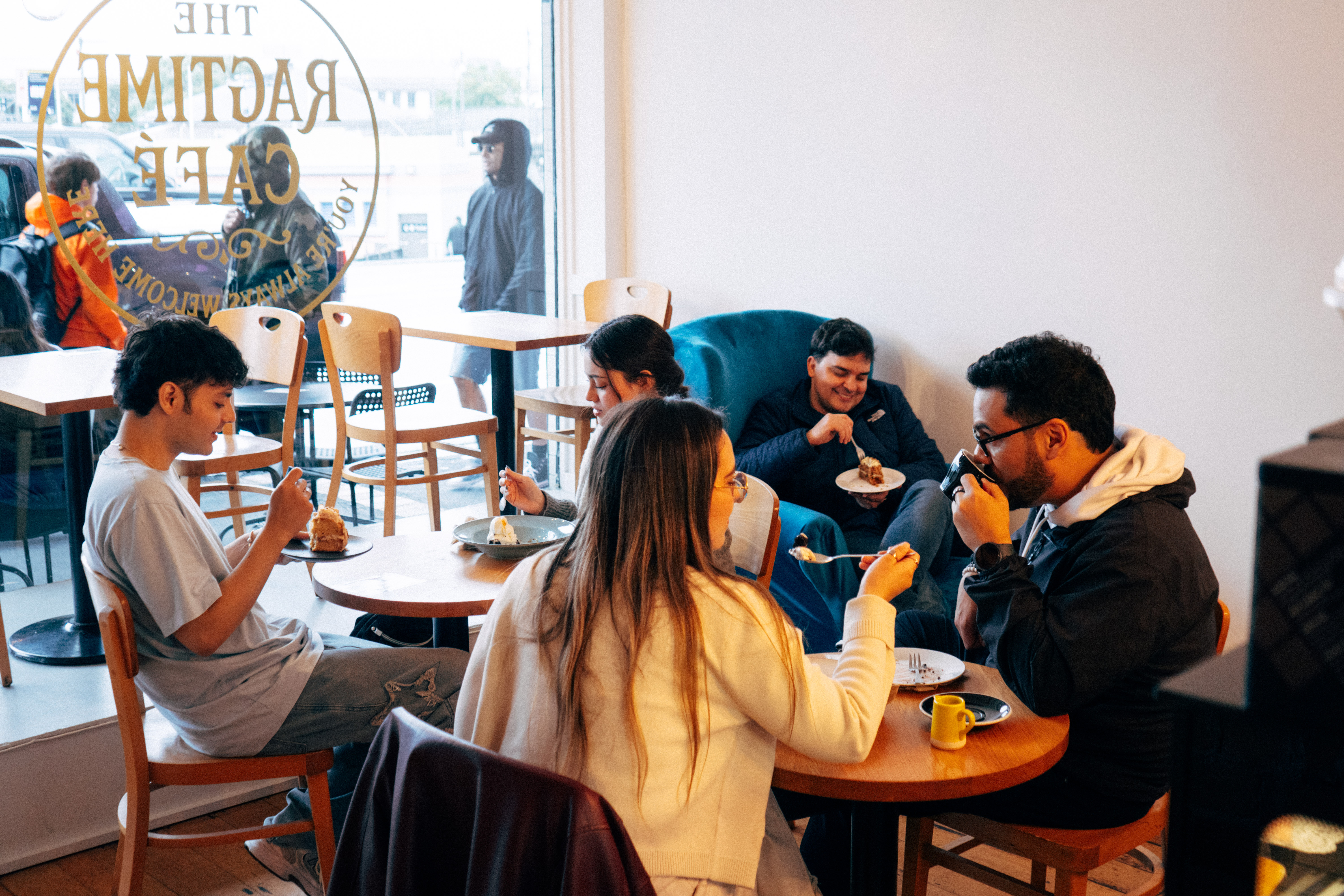 Friends enjoying cake and coffee together inside The Ragtime Café